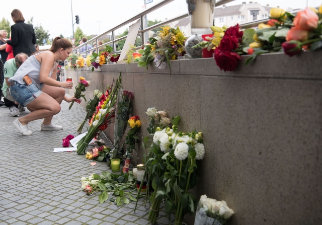 Lidé nosí květiny k provizornímu památníku poblíž místa střelby.