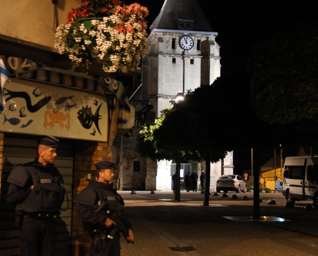 Francouzští policisté hlídkují před kostelem v Saint-Étienne-du-Rouvray. Kvůli vyšetřování se dělají prohlídky na několika místech v Normandii.
