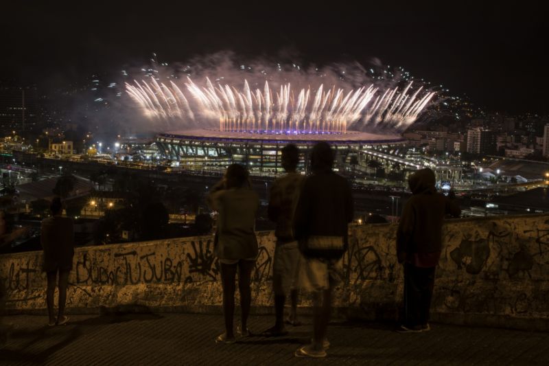 Ohňostroj nad stadionem v kontrastu se zdí chudinské čtvrti.