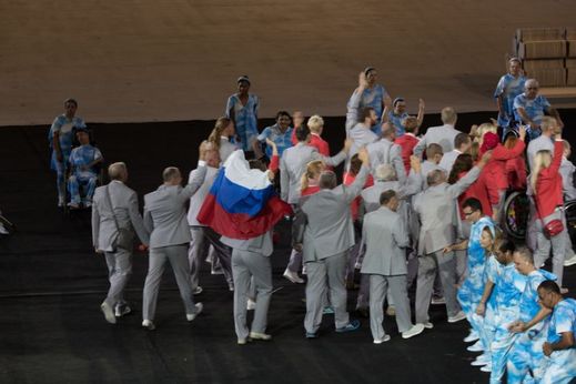 Běloruská paralympijská výprava s rozvinutou ruskou vlajkou.
