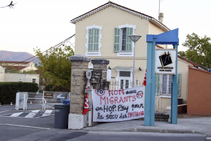 Francouzští vesničané protestují proti vládnímu plánu umístění migrantů do opuštěného křídla psychiatrické léčebny v Pierrefeu v jihovýchodní Francii. Transparent hlásá: Nechceme migranty na psychiatrické léčebně kvůli bezpečnosti pacientů.