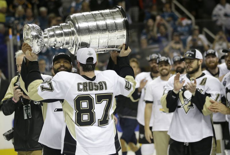 Sidney Crosby zvedá nad hlavu Stanley Cup.