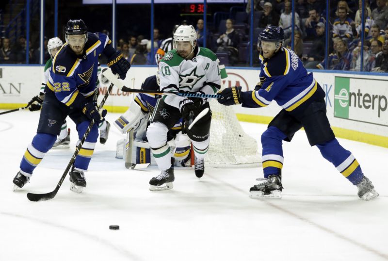 Dallaský hráč Patrick Sharp (10) bruslí mezi hokejisty St. Louis Kevinem Shattenkirkem (22) a Carlem Gunnarssonem.
