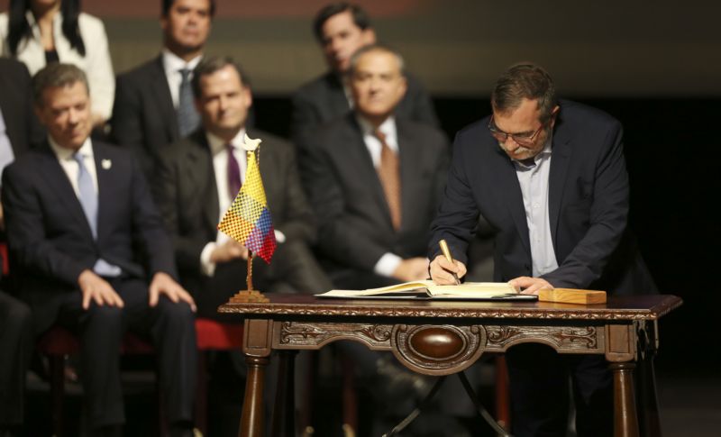 Vůdce rebelů FARC Rodrigo Londono podepisuje mírovou dohodu.