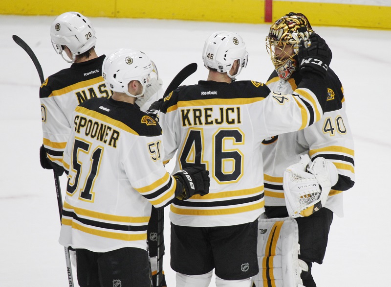 Hokejista Bostonu Bruins David Krejčí se raduje z výhry se svými spoluhráči.