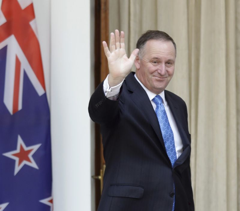 John Key mává novinářům.