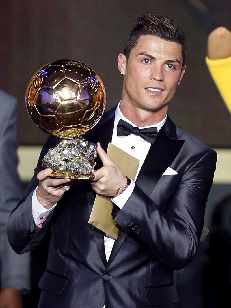 Cristiano Ronaldo pózuje se Zlatým míčem.