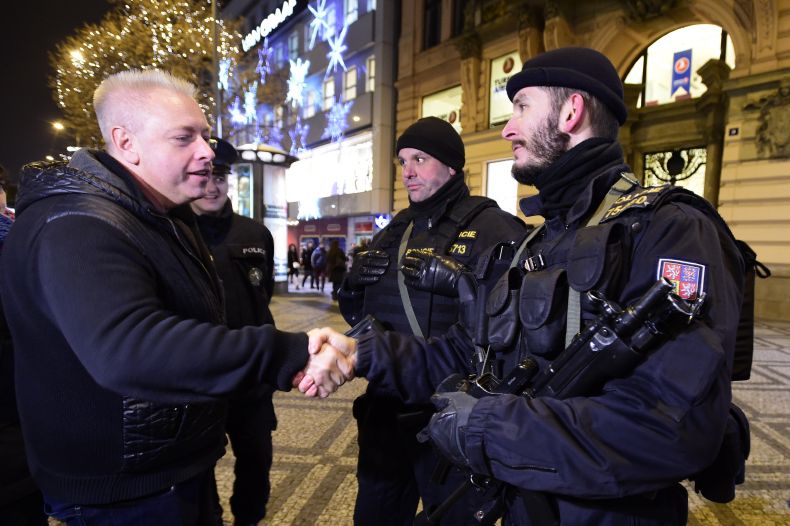 Ministr vnitra  Milan Chovanec (ČSSD) se zdraví s policisty v ulicích Prahy.