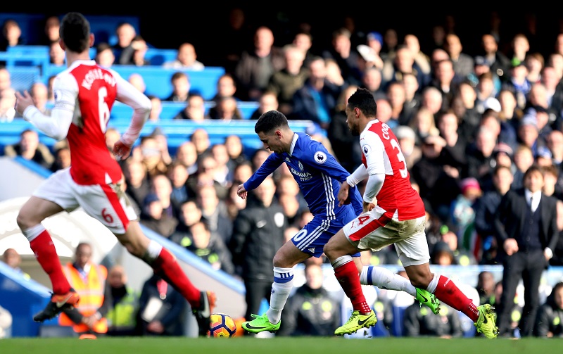 Eden Hazard (v modrém) vstřelil druhý gól Chelsea v utkání. Zde uniká svému soupeři Francisu Coquelinovi z Arsenalu.