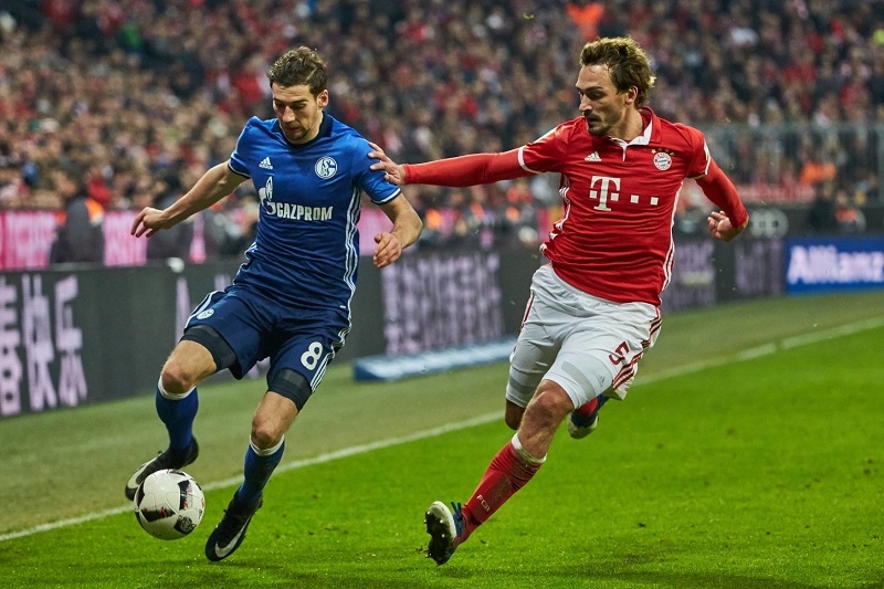 Leon Goretzka ze Schalke (vlevo) stíhán stoperem Bayernu Mnichov Matsem Hummelsem.