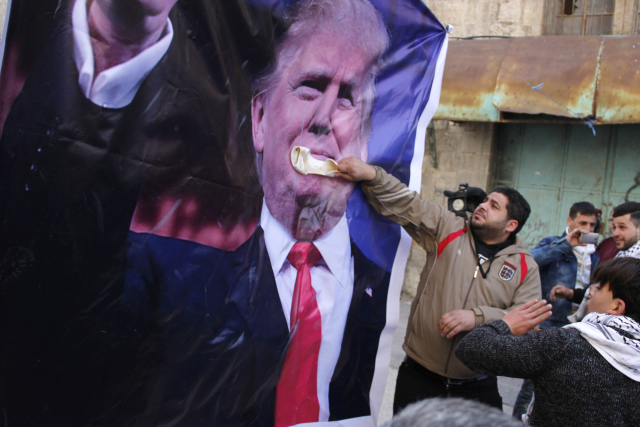 Protestující házeli staré boty na dvoumetrový plakát s Trumpem.