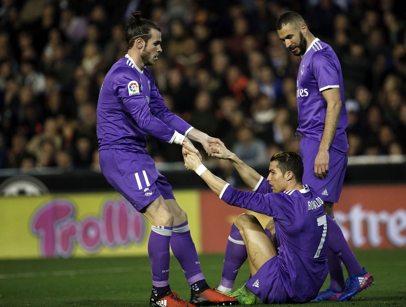 Fotbalisté Realu Madrid. Gareth Bale (vlevo) pomáhá na nohy Ronaldovi.