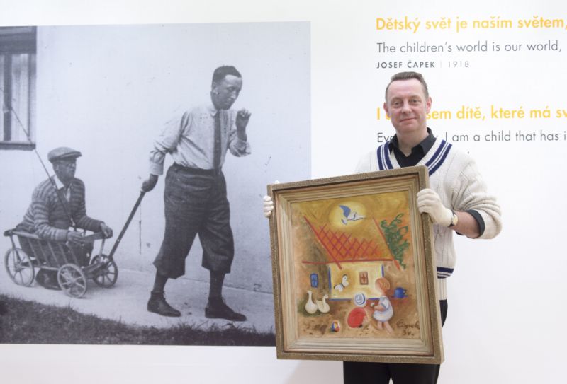 Kurátor Richard Drury ukazuje Čapkův obraz Dvoreček z roku 1934. Na snímku v pozadí bratři Čapkové.