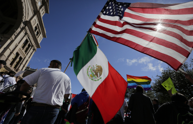 Účastníci protestní akce proti imigračnímu dekretu Dolanda Trumpa nesou americké a mexické vlajky jako projev vzájemné solidarity.
