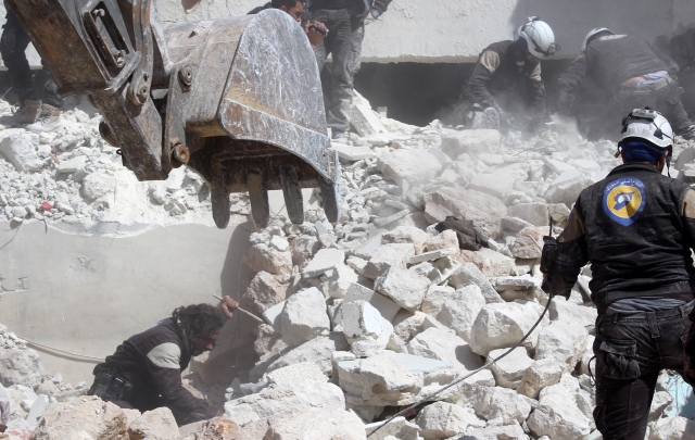 Záchranáři zabezpečují místo po vzdušných náletech v syrském městě Idlib.