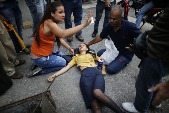 Žena zasažená slzným plynem při protivládním protestu ve venezuelské metropoli Caracas.
