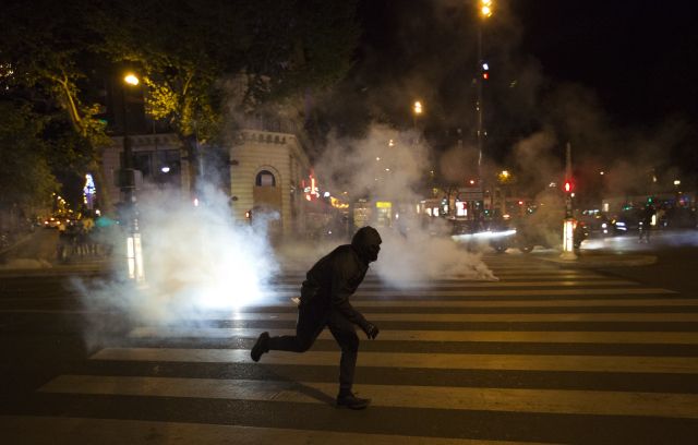 Jeden z účastníků demonstrace prchá před slzným plynem.