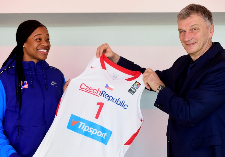 Reprezentační trenér Ivan Beneš pózuje s dresem pro americkou posilu českého týmu - Kiu Vaughnovou.