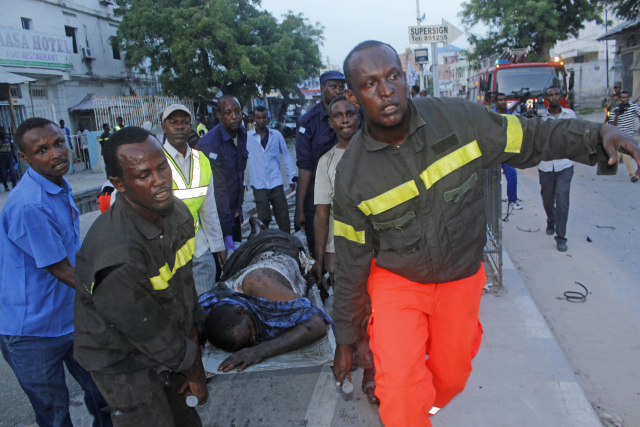 Somálští záchranáři odnášejí muže zraněného následkem exploze bomby v metropoli Mogadišo. Somálští záchranáři odnášejí muže zraněného následkem exploze bomby v metropoli Mogadišo.