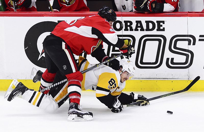 Obránce Ottawy Marc Methot v souboji s kapitánem Pittsburghu Sidneym Crosbym.