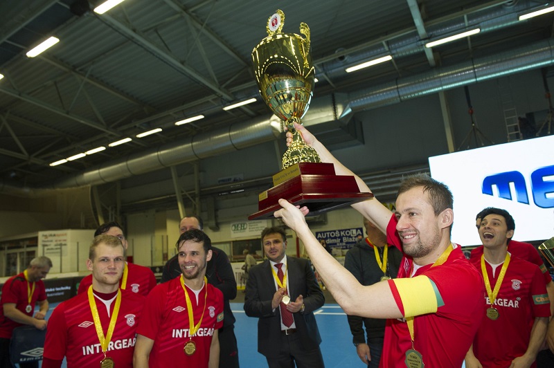 Lukáš Rešetár zvedá nad hlavu pohár pro mistry české ligy ve futsale.