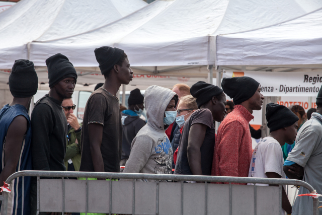 Snímek migrantů v italském přístavu.