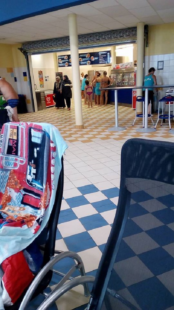Snímek zahalených žen, které si kupují občerstvení.