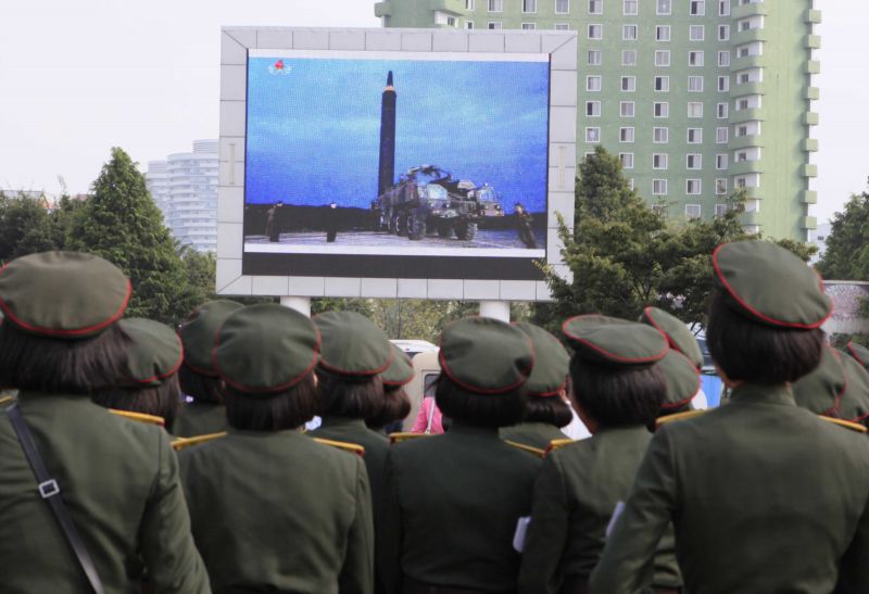 Lidé v Pchjongjangu sledují raketový test na obrazovkách.