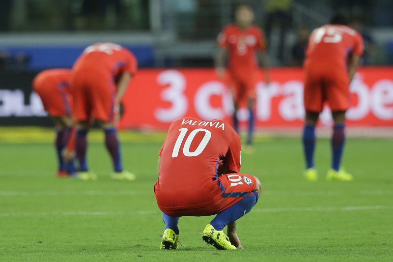 Fotbalisté Chile smutní nad prohrou s brazilskými fotbalisty.