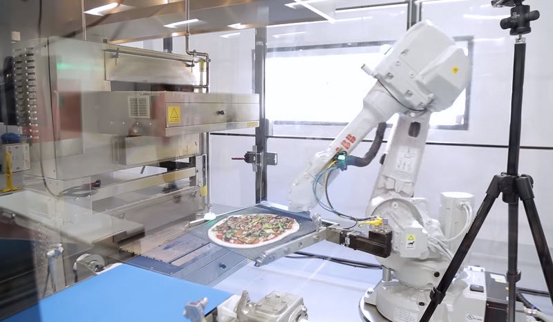 Zuma Pizze robot dávající pizzu do pece.