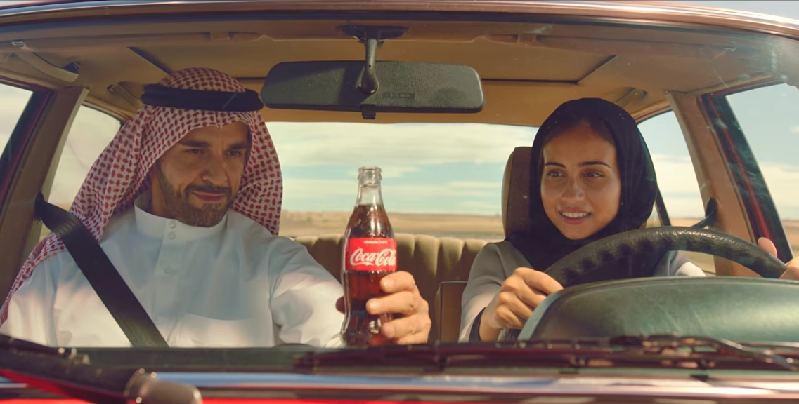 V reklamě na Coca-Colu učí otec svou dceru řídit auto.