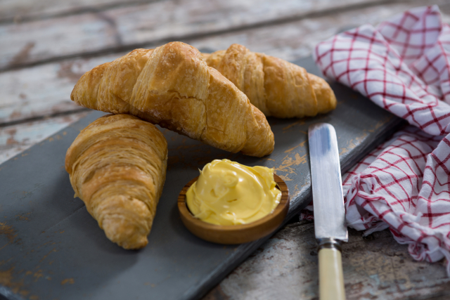 Croissant s máslem, typická francouzská pochoutka.