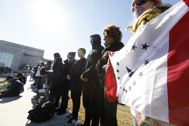 Demonstranti s vlajkou státu Mississippi.