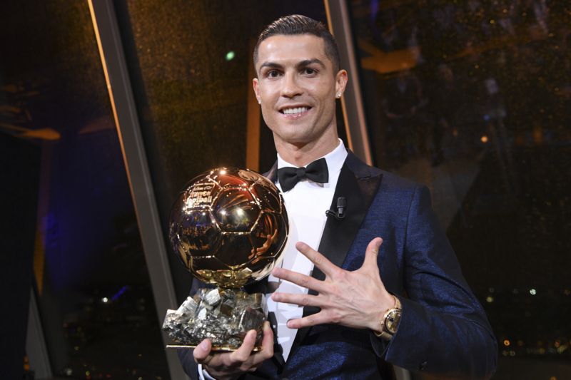 Cristiano Ronaldo pózuje se Zlatým míčem.