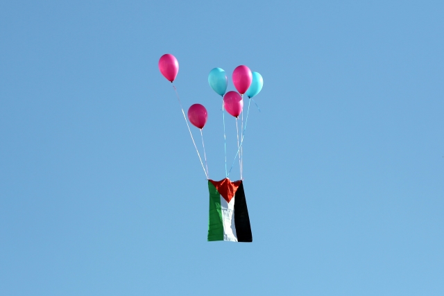 Palestinská vlajka letí do vzduchu během protestů proti Trumpově výrokům. 