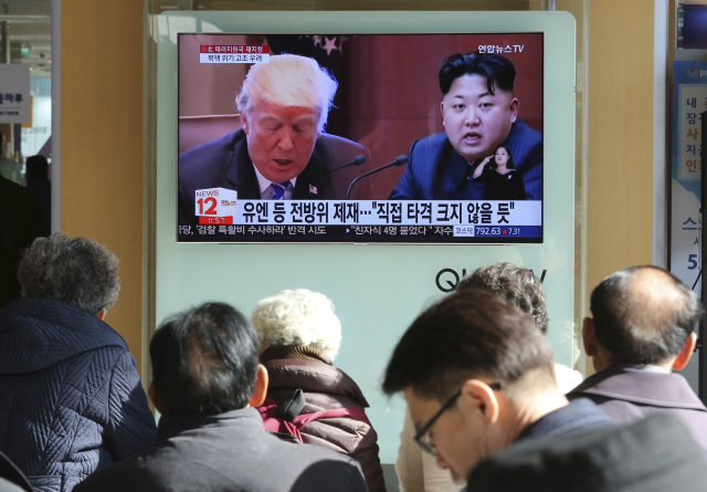 Americký prezident Donald Trump (vlevo) a severokorejský vůdce Kim Čong-un na televizní obrazovce.