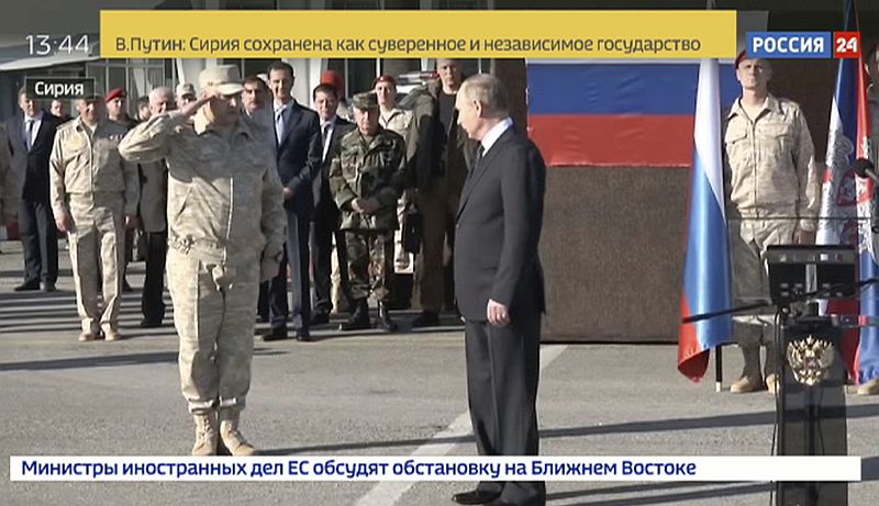 Ruský prezident Vladimir Putin při návštěvě Sýrie. V pozadí v obleku stojí syrský prezident Bašár Asad.
