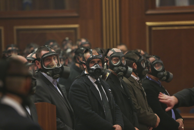 Ochranka kosovské sněmovny s plynovými maskami. 