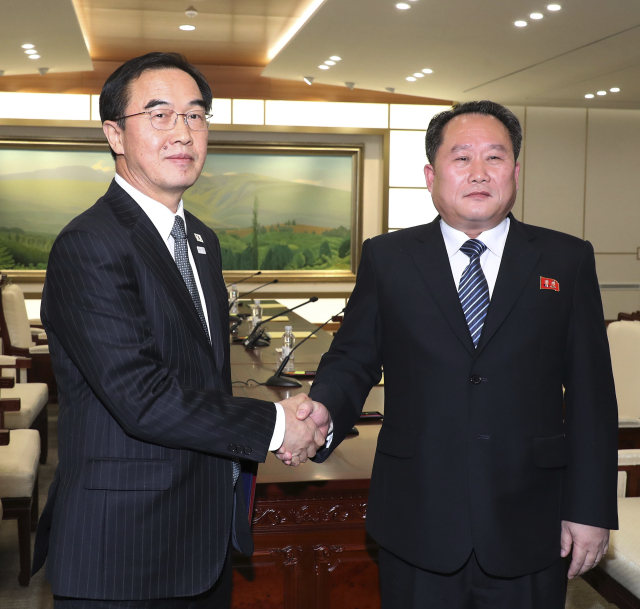 Jihokorejský ministr pro sjednocení ostrova Cho Myoung-gyon (vlevo) a šéf severokorejské delegace Ri Son Gwon. Jihokorejský ministr pro sjednocení ostrova Cho Myoung-gyon (vlevo) a šéf severokorejské delegace Ri Son Gwon.