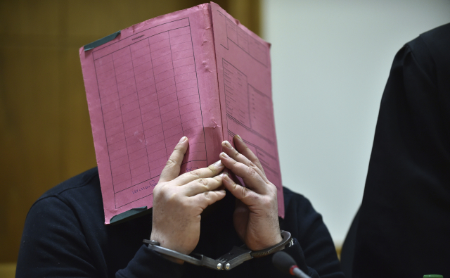 Niels Högel zakrývající si obličej při soudním procesu v roce 2015. Niels Högel zakrývající si obličej při soudním procesu v roce 2015.