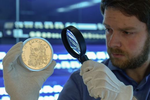 Na snímku kurátor výstavy Zdeněk Štafl ukazuje v expozici zlatou minci ze sady Karla IV., která byla roku 1999 vyhodnocena jako nejkrásnější mince světa.