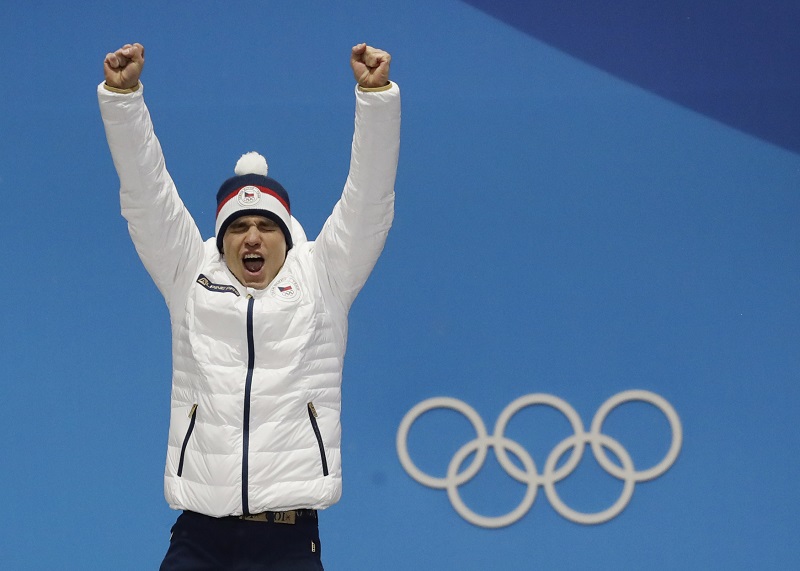 Biatlonista Michal Krčmář při přebírání olympijské medaile.
