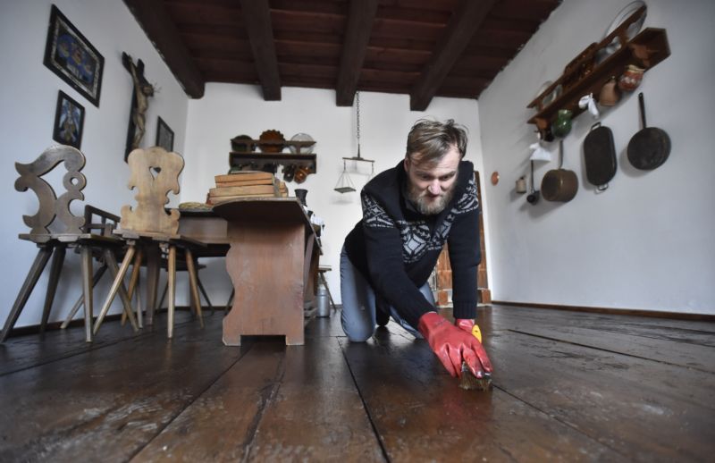 Restaurátor Edmond Chlud pracuje na obnově podlahy.