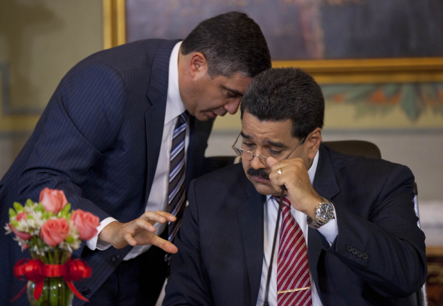 Exministr vnitra Miguel Rodríguez Torres (vlevo) a venezuelský prezident Nicolás Maduro (vpravo).
