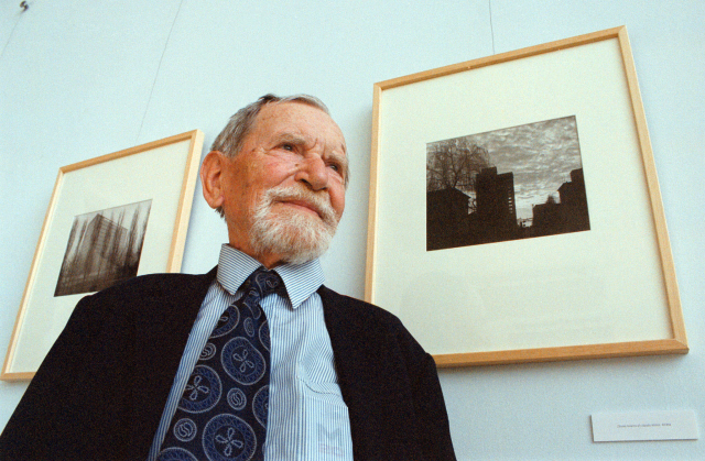 Fotograf a kameraman Antonín Horák před svými snímky při vernisáži výstavy, která se konala 12. května 2003 v Městském divadle ve Zlíně. 