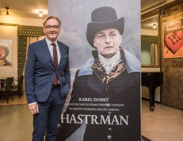 Režisér filmu Ondřej Havelka před plakátem Hastrmana. 
