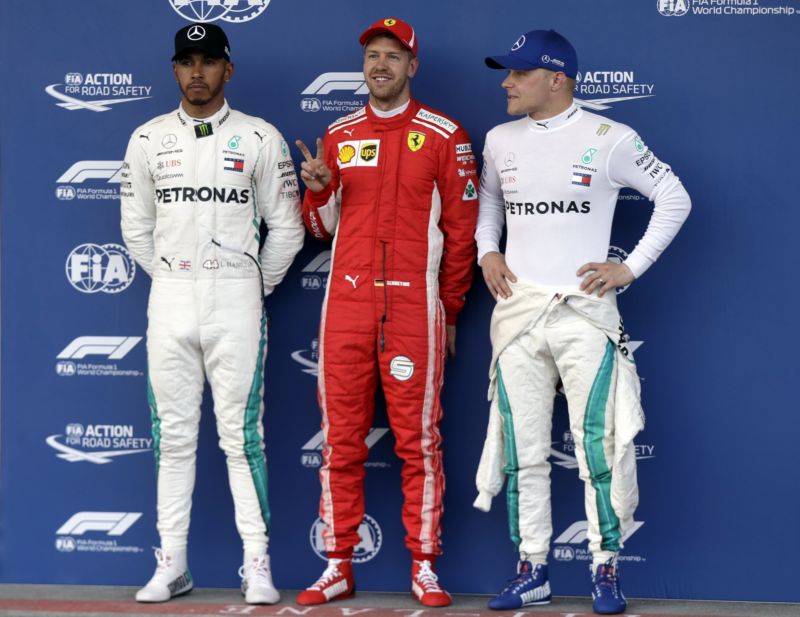 Vítěz Sebastian Vettel (uprostřed) společně s Hamiltonem (vlevo) a Bottasem. 