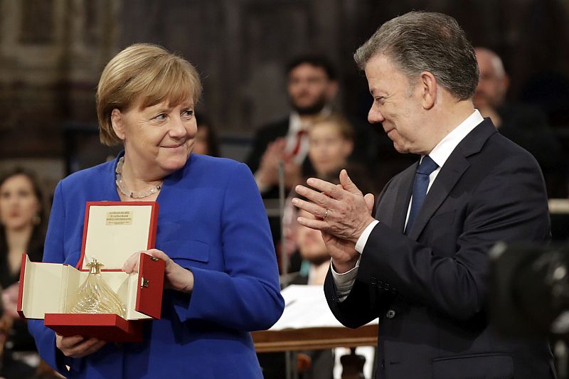 Německá kancléřka Angela Merkelová přebírá od kolumbijského prezidenta Juana Manuela Santose ocenění za úsilí o smír a mírové spolužití v Německu i v Evropě.