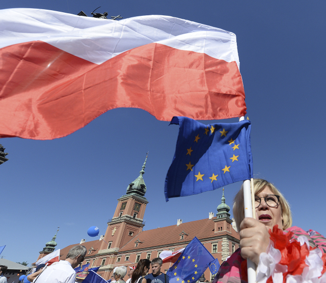 Řada účastníků akce nesla během průchodu Varšavou vlajky Polska a Evropské unie.