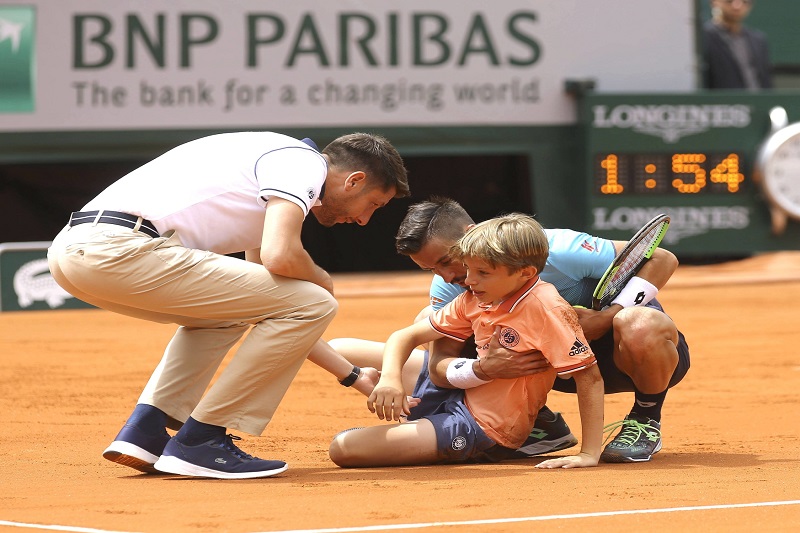 Damir Džumhur se při utkání třetího kola French Open nechtěně srazil s mladým podavačem míčků. Damir Džumhur se při utkání třetího kola French Open nechtěně srazil s mladým podavačem míčků.